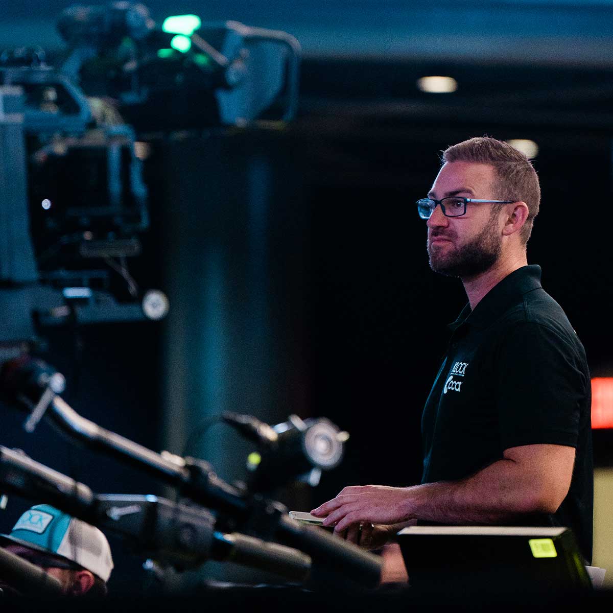 A man with glasses operating video production equipment