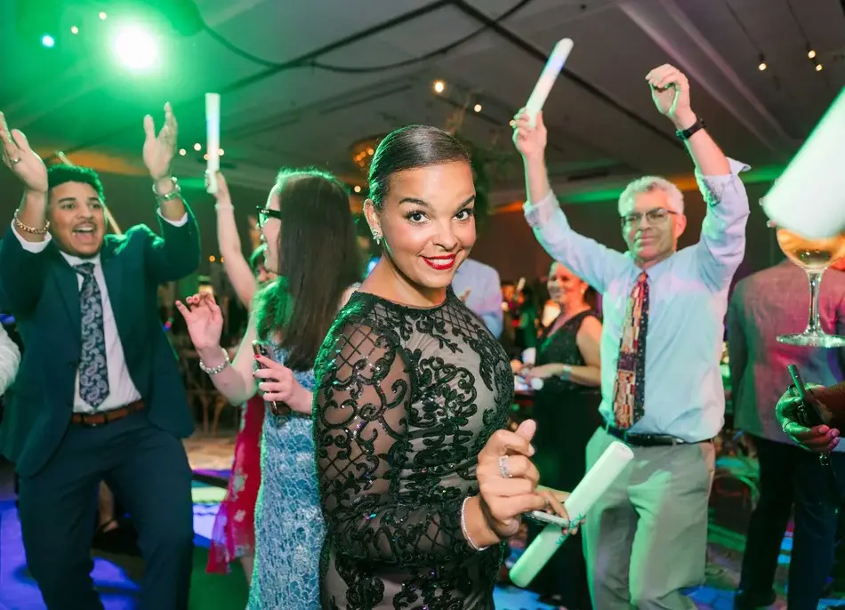 A guest in a black lace dress at the center of the party