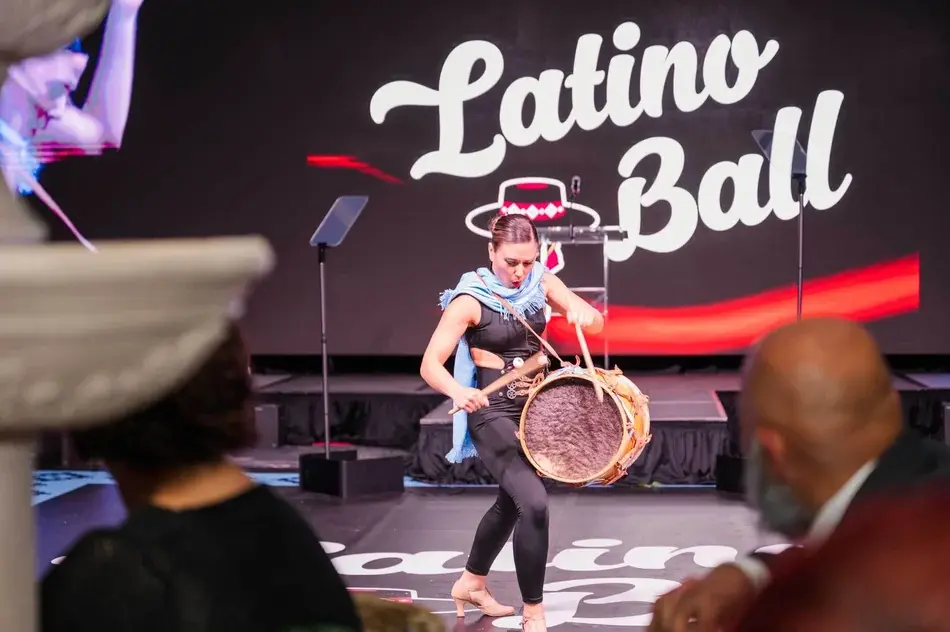 A performer plays a drum on stage at the Latino Ball